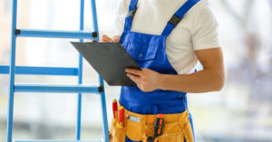 A maitnenace worker holding a clipboard doing make ready maintenance for an apartment