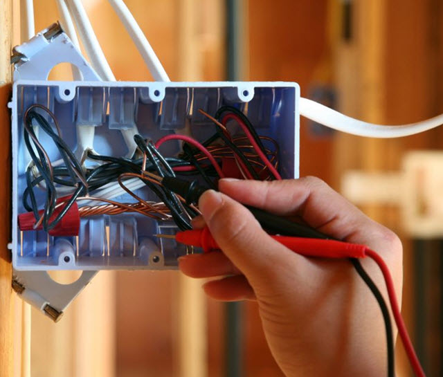 Electrician fixing electrical box, illustrating hands-on training in the Skilled Trades Workforce Development