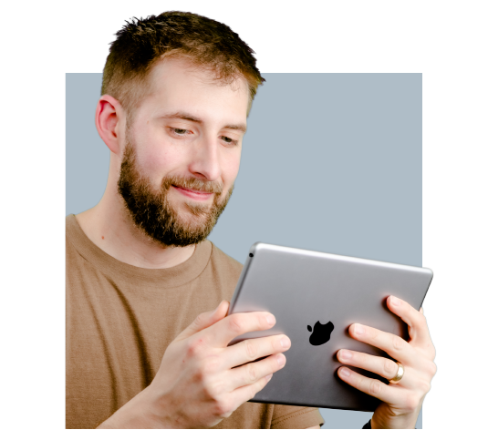 A man with a beard holding an iPad doing simulation-based commercial HVAC training