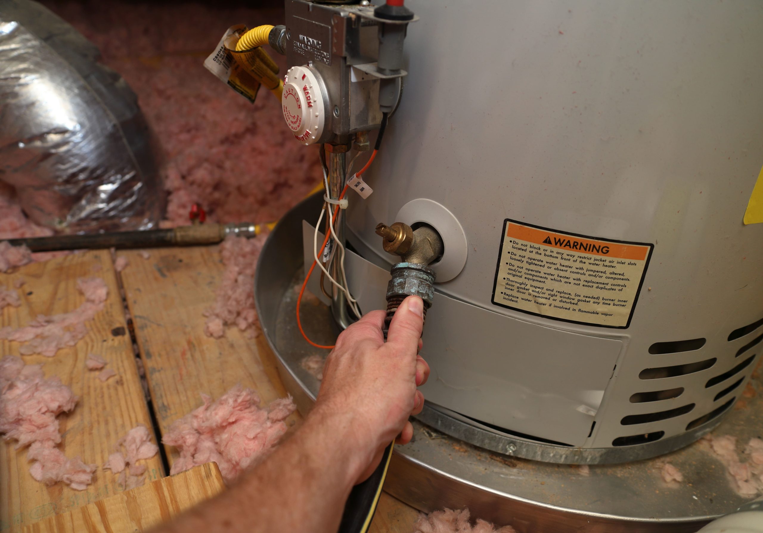 A man is working on a hot water heater