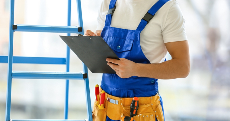 A maintenance worker holding a clipboard doing make ready maintenance for an apartment