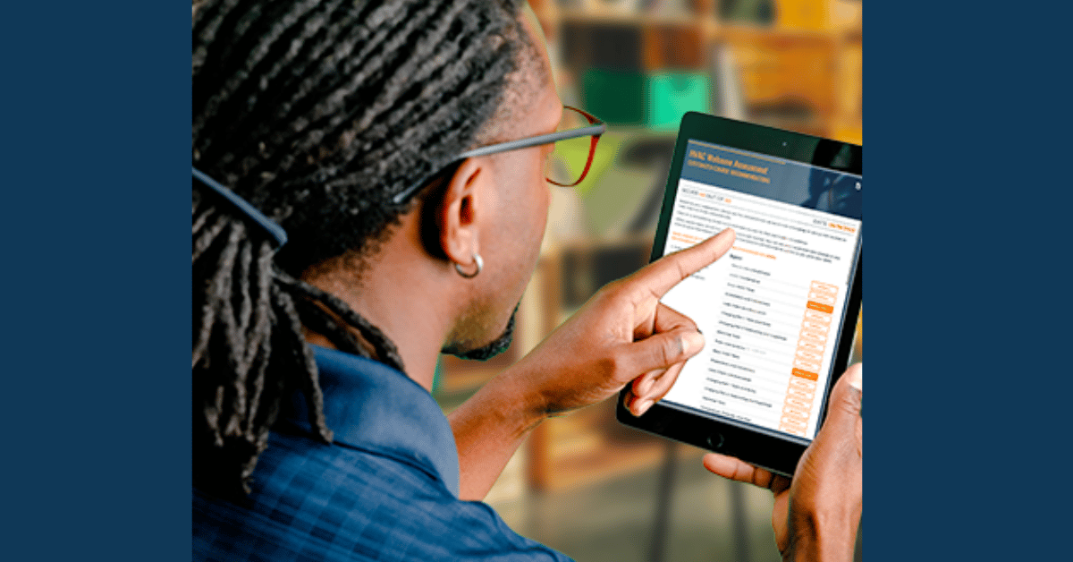 A man with dreadlocks using a tablet computer.