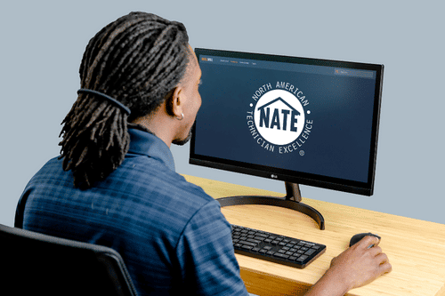 Man engaging with NATE Training content on a computer for professional HVAC training.