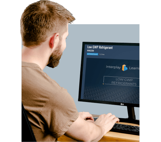 A man sitting at a desk using a computer for NATE Low-GWP Refrigerants Certification