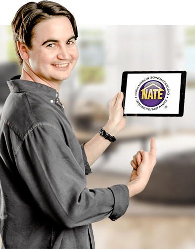 A man holding a laptop that displays the NATE Training Academy while pointing to it