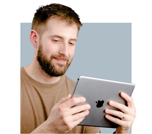 A man with a beard holding an iPad doing simulation-based commercial HVAC training
