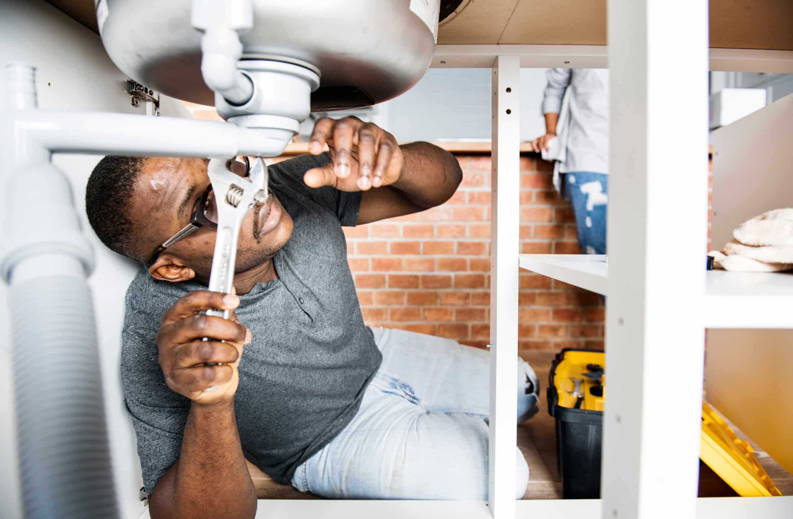 A male apprentice fixing a sink as part of a registered apprenticeship program
