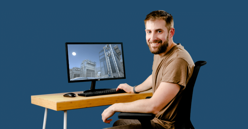 A man sitting at a desk with a computer displaying an online commercial hvac training course