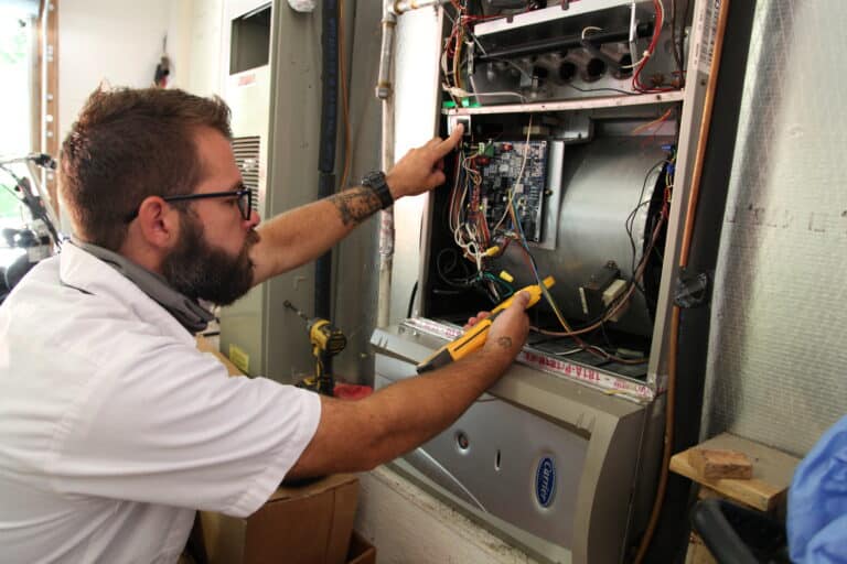 Man working on a hvac unit showing strong HVAC Business Management
