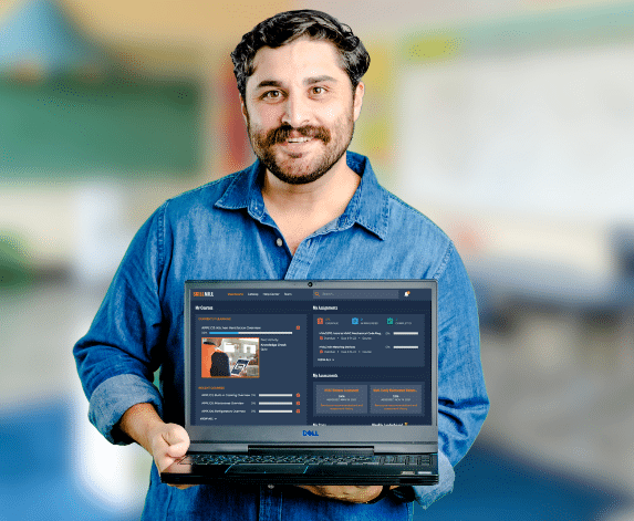 A man in a blue shirt holding a laptop and showing the Skillmill application for skilled trades training