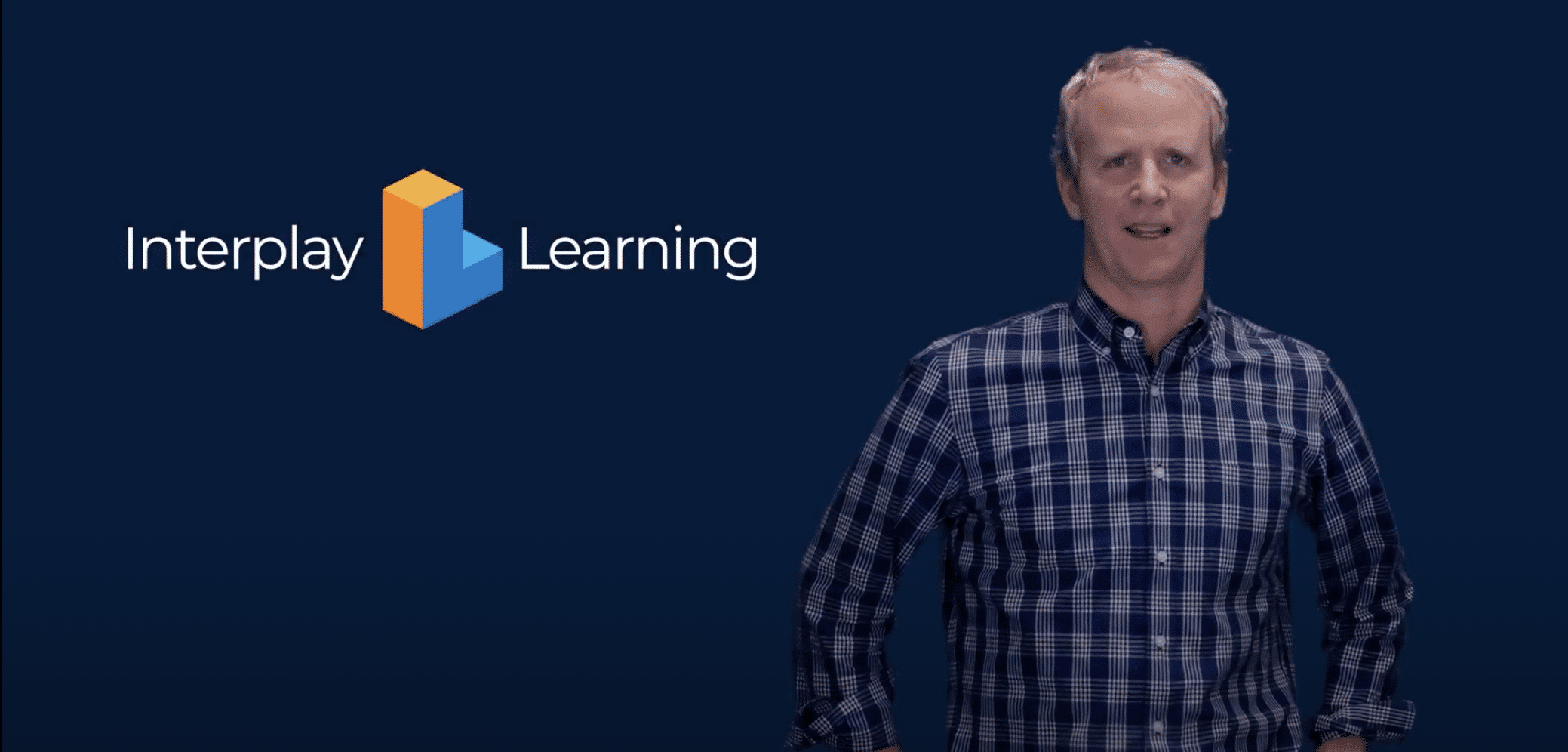 A man standing in front of an Interplay Learning logo