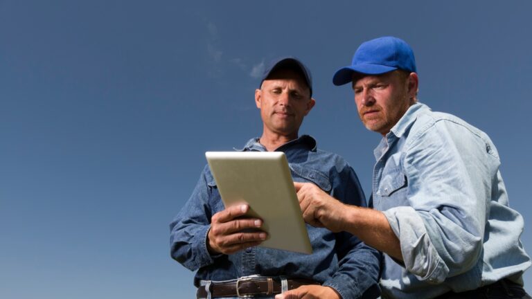 Two men standing next to each other with a tablet usign it for HVAC technician training
