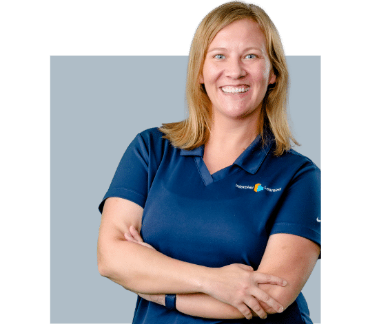 A smiling Interplay Learning Expert woman in a blue shirt with her arms crossed