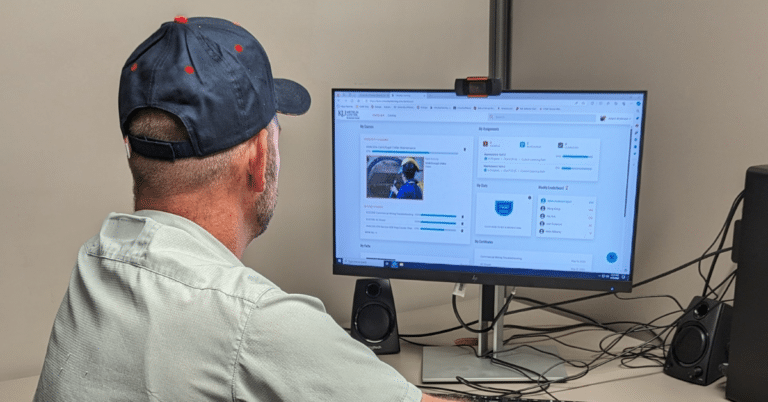 a man sitting in front of a computer monitor