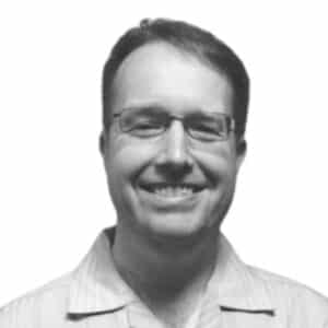 a black and white photo of a smiling man