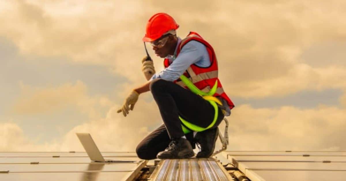 a man on a roof working on a laptop