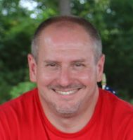 a man in a red shirt sitting at a table