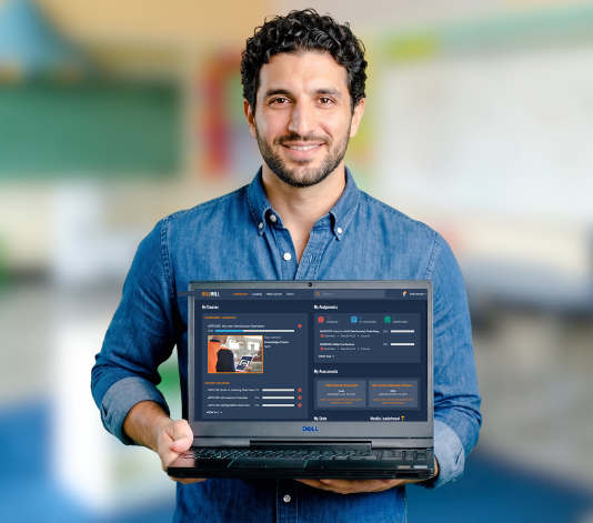 A man in a blue shirt holding a laptop and showing the Skillmill application for skilled trades training