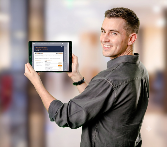 A man in a grey shirt holding a tablet and showing the Skillmill application for skilled trades training