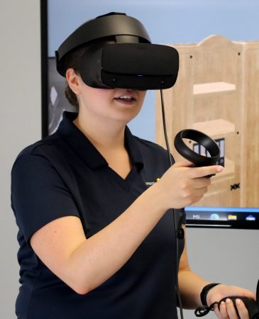vr-training-woman A woman wearing a VR headset for a 3D simulation service team trainig course that uses visual baselining